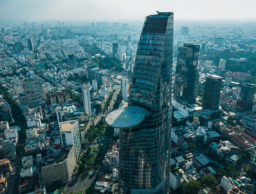 Drone Photo Of Bitexco Financial Tower With Cantilevered Helipad On The 55th Floor In The Center Of District 1 With Public Parks Constructions And Buildings In The Background In Ho Chi Minh City Vietnam